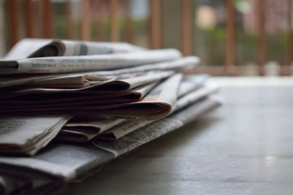 A stack of newspapers on a table.