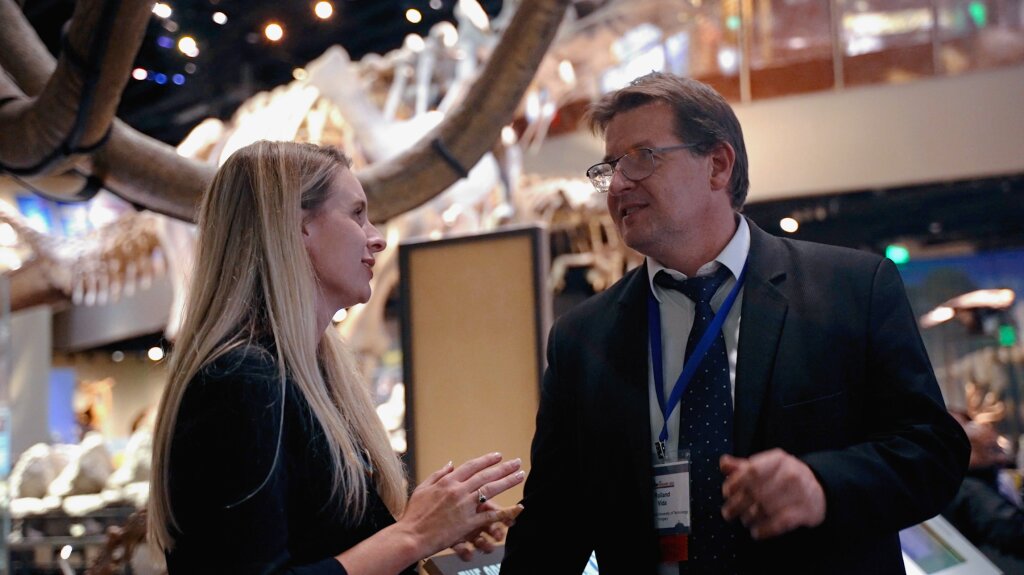 A Conference Catalysts staff member in conversation with an attendee at an event held in a museum.