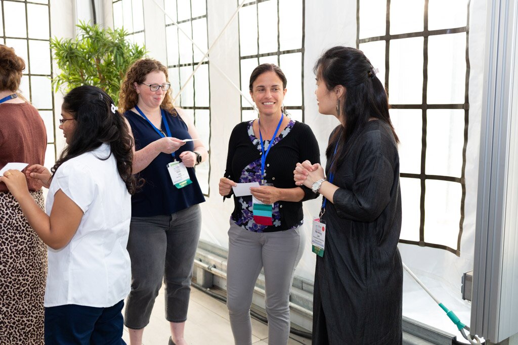 Attendees chatting and exchanging business cards during a networking break.