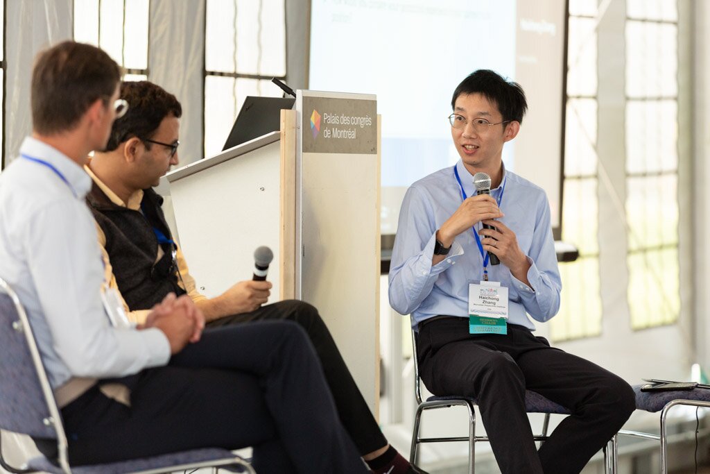 A panelist speaking into a microphone during a panel discussion.